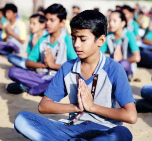 In the midst of a crowd, a boy quietly practices meditation, finding calm in a communal environment