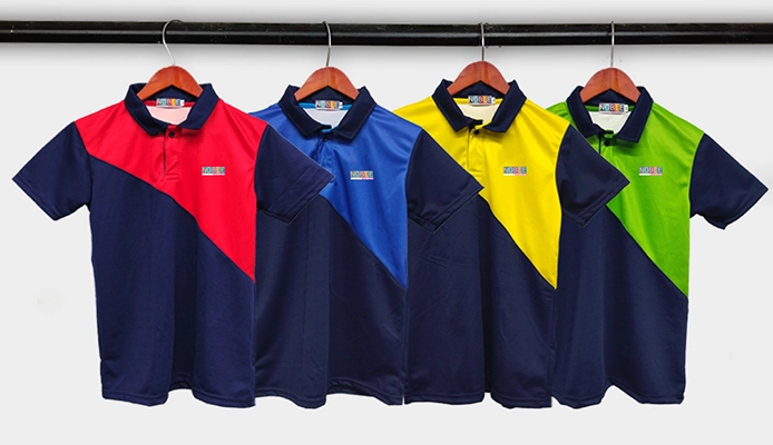 Top 5 Tips to Select The Best Sports Uniform For School Kids Multiple school sports uniforms in red, blue, yellow, and green hanging neatly on wooden hangers