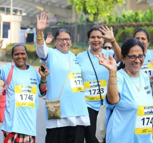A gathering of women dressed in blue tshirts and track pants, standing together as a united group