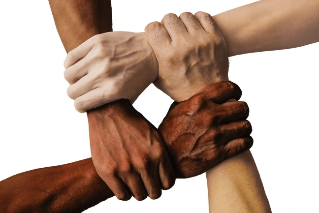 Hands of diverse races clasping in unity,symbolizing harmony among people of different ethnic background in active wear