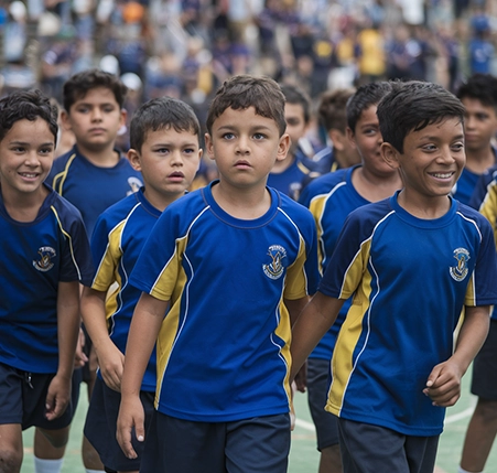 Best School Sports Jerseys Manufacturer in Mumbai The Children in school uniforms, filled with joy, dance together, showcasing teamwork and enthusiasm.